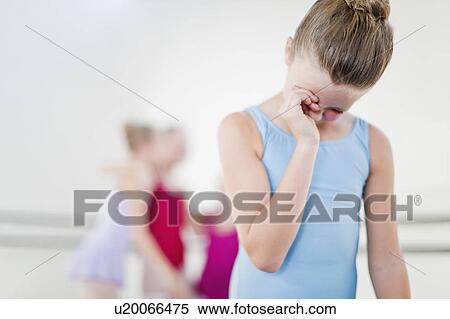 Stock Photography - Ballet dancer wiping her eyes in studio. Fotosearch