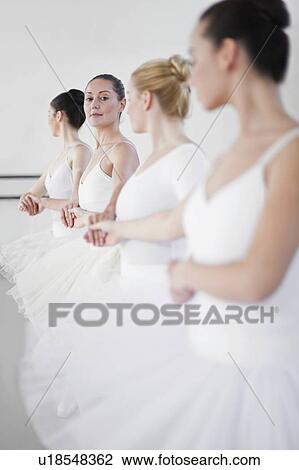 Stock Image - Ballet dancers holding hands in studio. Fotosearch