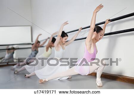 Stock Image - Ballet dancers posing at barre. Fotosearch