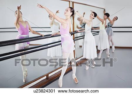 Stock Image - Ballet dancers posing at barre. Fotosearch