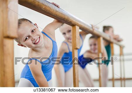Stock Photo - Ballet dancers standing at barre. Fotosearch