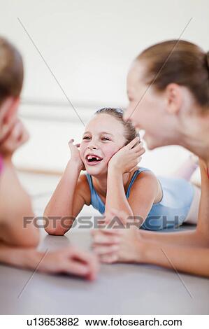 Stock Image - Ballet dancers talking on studio floor. Fotosearch