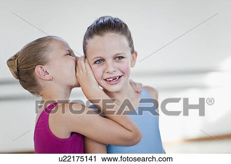 Stock Image - Ballet dancers whispering in studio. Fotosearch