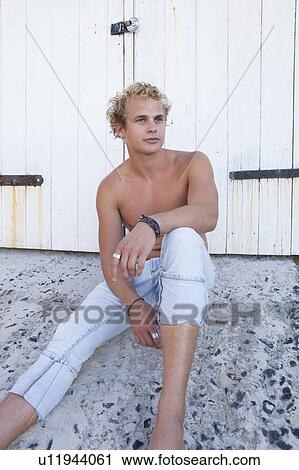 Bare-chested man sitting near door View Large Photo Image Stock Image - Bare-chested man sitting near door. Fotosearch