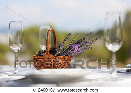 Stock Photo - Basket of flowers on set table. Fotosearch