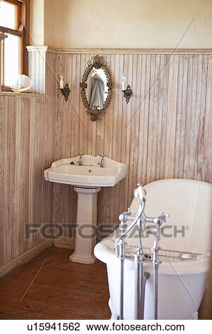 Stock Image - Bathroom with ornate tub and mirror . Fotosearch