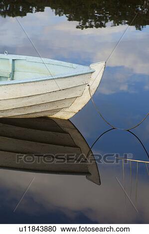 Stock Image - Boat reflected in still lake. Fotosearch