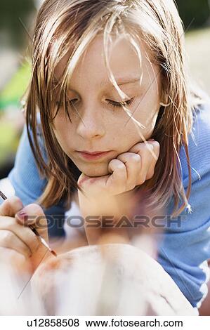 Stock Photo - Bored girl painting outdoors. Fotosearch
