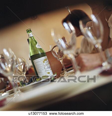 Stock Image - Bottle of wine on set table. Fotosearch