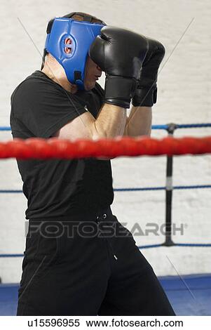 Stock Photography - Boxer covering his face in ring. Fotosearch