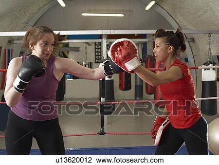 Stock Image - Boxer training with coach in gym. Fotosearch
