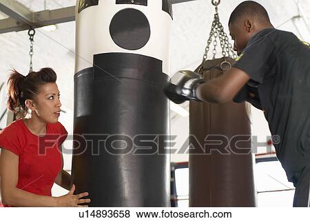 Stock Photo - Boxer training with coach in gym. Fotosearch