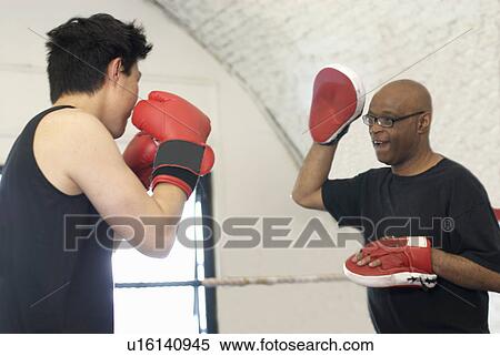 Boxer training with coach in gym View Large Photo Image Stock Photography - Boxer training with coach in gym. Fotosearch