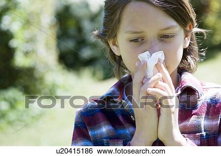 Stock Photograph - Boy blowing his nose outdoors. Fotosearch