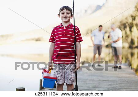 Boy carrying fishing rod on jetty View Large Photo Image Picture - Boy carrying fishing rod on jetty. Fotosearch