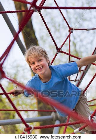 Boy climbing at playground View Large Photo Image Stock Image - Boy climbing at playground. Fotosearch