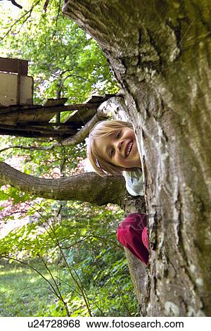 Stock Photo - Boy climbing in tree house. Fotosearch