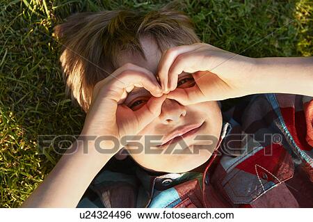 Stock Photograph - Boy cupping hands over his eyes. Fotosearch