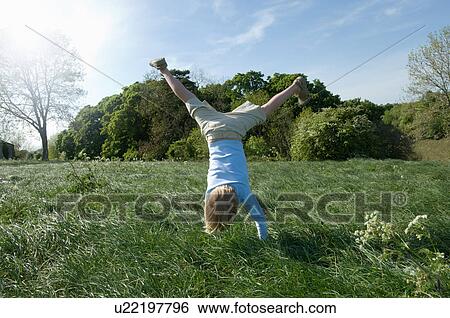 Boy doing handstand in field View Large Photo Image Stock Photograph - Boy doing handstand in field. Fotosearch
