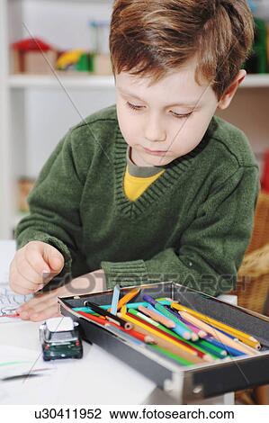 Stock Image - Boy drawing with colored pencils. Fotosearch
