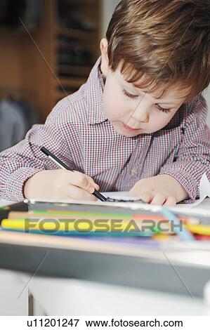 Stock Photo - Boy drawing with colored pencils. Fotosearch