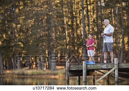 Boy fishing with grandfather in lake View Large Photo Image Picture - Boy fishing with grandfather in lake. Fotosearch
