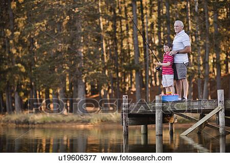 Boy fishing with grandfather in lake View Large Photo Image Stock Photo - Boy fishing with grandfather in lake. Fotosearch