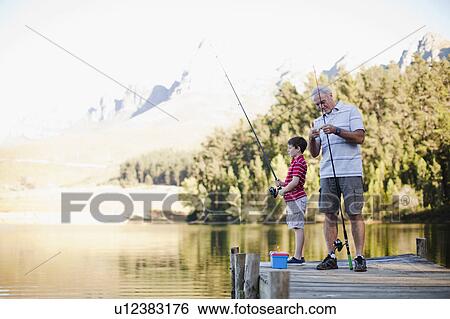 Boy fishing with grandfather in lake View Large Photo Image Stock Photograph - Boy fishing with grandfather in lake. Fotosearch