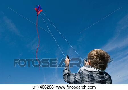 Stock Photo - Boy flying a kite. Fotosearch