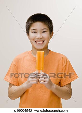 Stock Image - Boy holding a popsicle. Fotosearch