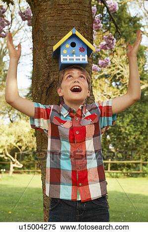 Boy holding birdhouse on his head View Large Photo Image Stock Photography - Boy holding birdhouse on his head. Fotosearch