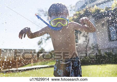 Picture - Boy in snorkel playing with hose. Fotosearch