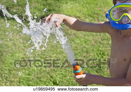 Stock Photography - Boy in snorkel playing with hose. Fotosearch