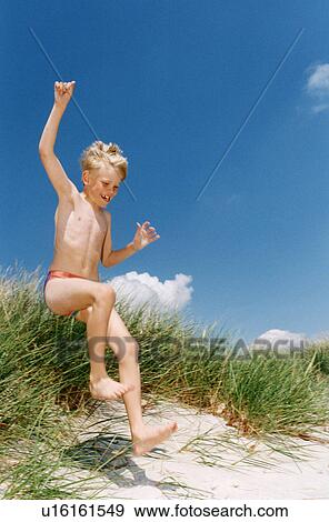 Boy in swimsuit playing on beach View Large Photo Image Stock Photo - Boy in swimsuit playing on beach. Fotosearch