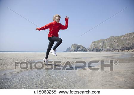 Boy jumping over pools on beach View Large Photo Image Stock Photography - Boy jumping over pools on beach. Fotosearch