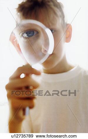 Boy peering through magnifying glass View Large Photo Image Stock Photo - Boy peering through magnifying glass. Fotosearch