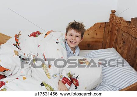 Stock Photograph - Boy playing in bed. Fotosearch