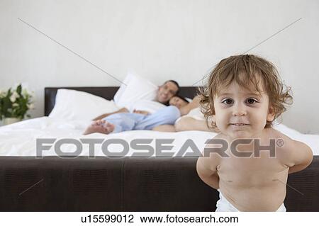 Stock Image - Boy playing in parents' bedroom. Fotosearch