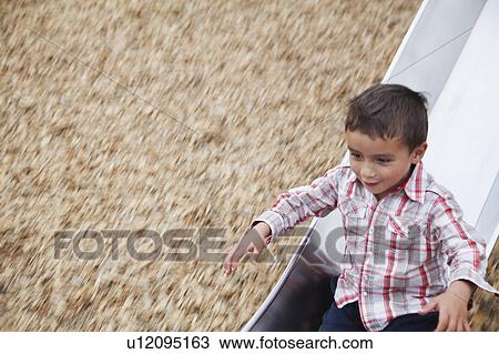 Boy playing on slide at playground View Large Photo Image Stock Image - Boy playing on slide at playground. Fotosearch