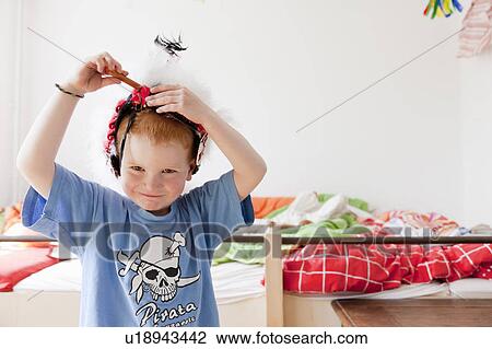 Boy playing with hat in bedroom View Large Photo Image Stock Image - Boy playing with hat in bedroom. Fotosearch