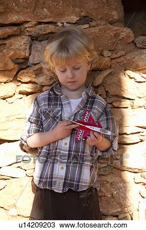 Boy playing with toy airplane outdoors View Large Photo Image Stock Image - Boy playing with toy airplane outdoors. Fotosearch