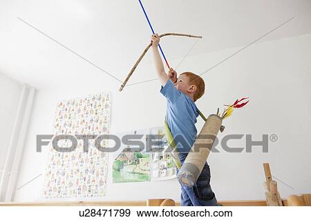 Boy playing with toy bow and arrow View Large Photo Image Stock Photo - Boy playing with toy bow and arrow. Fotosearch