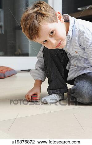 Stock Image - Boy playing with toy cars. Fotosearch