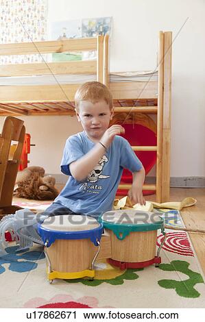 Boy playing with toy drums View Large Photo Image Stock Image - Boy playing with toy drums. Fotosearch