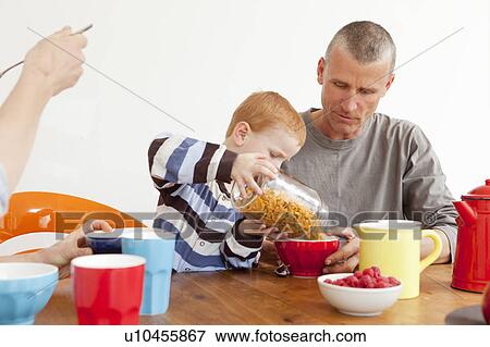 Boy pouring father bowl of cereal View Large Photo Image Stock Photo - Boy pouring father bowl of cereal. Fotosearch