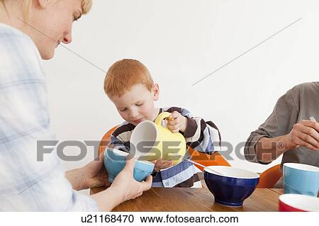 Boy pouring milk for mother View Large Photo Image Stock Image - Boy pouring milk for mother. Fotosearch