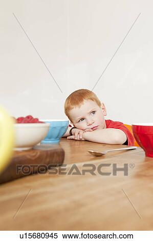 Boy resting his head at dinner table View Large Photo Image Stock Photography - Boy resting his head at dinner table. Fotosearch