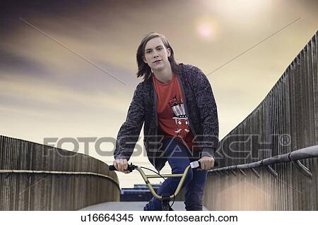 Stock Photography - Boy riding bicycle on walkway. Fotosearch