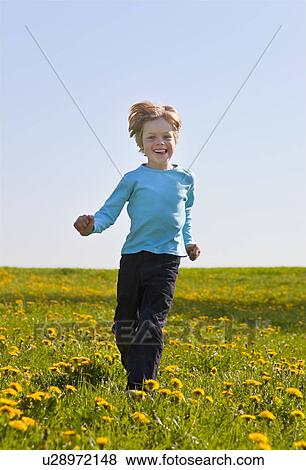 Boy running in field of flowers View Large Photo Image Stock Photo - Boy running in field of flowers. Fotosearch