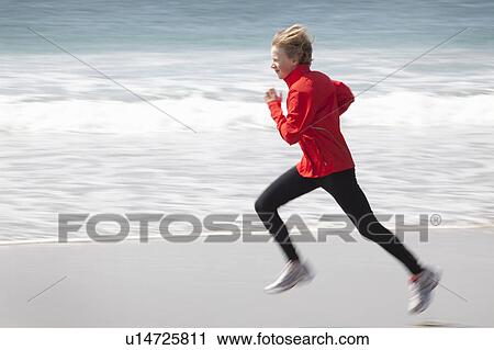 Stock Image - Boy running on beach. Fotosearch
